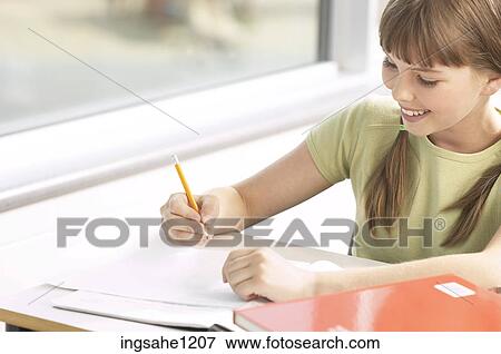 Stock Photo - Little girl writing at her desk 2. Fotosearch