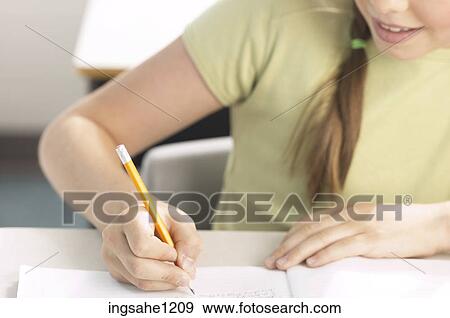 Stock Photo - Little girl writing at her desk 8. Fotosearch