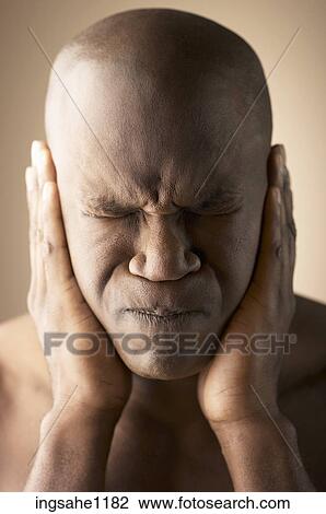 Stock Image - Man covering his ears with his hands. Fotosearch
