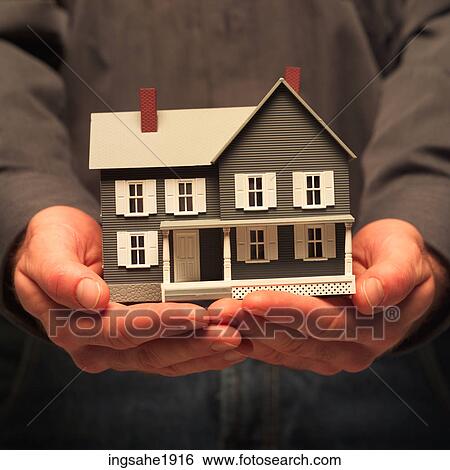 Man holding house BE View Large Photo Image Stock Photograph - Man holding house BE. Fotosearch