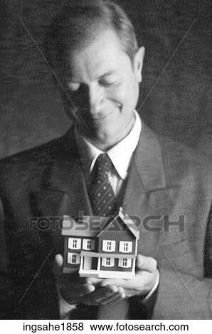 Man holding model house BE 6 View Large Photo Image Stock Photo - Man holding model house BE 6. Fotosearch