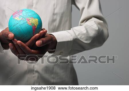 Man in white shirt holding globe BE View Large Photo Image Stock Photo - Man in white shirt holding globe BE. Fotosearch