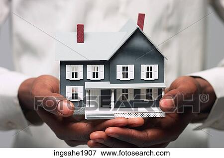 Man in white shirt holding house BE View Large Photo Image Stock Photo - Man in white shirt holding house BE. Fotosearch