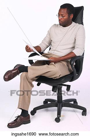 Stock Image - man reading in chair BE 6. Fotosearch