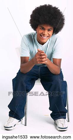Stock Image - Man with afro sitting on stool and smiling. Fotosearch