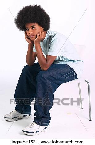 Man with afro slouching on stool a82 View Large Photo Image Stock Image - Man with afro slouching on stool a82. Fotosearch