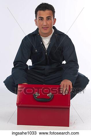 Stock Image - Mechanic kneeling over open toolbox. Fotosearch