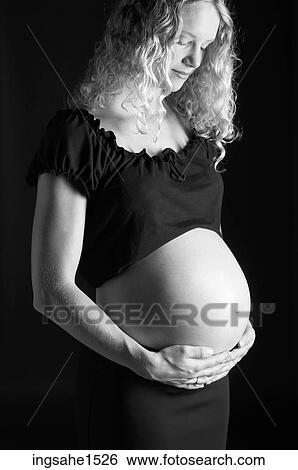 Stock Photograph - Pregnant woman holding belly . Fotosearch