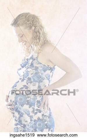 Pregnant woman in blue floral dress View Large Photo Image Stock Photo - Pregnant woman in blue floral dress. Fotosearch