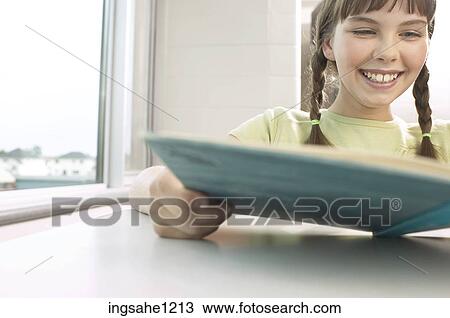 Smiling little girl reading book in classroom View Large Photo Image Stock Image - Smiling little girl reading book in classroom. Fotosearch