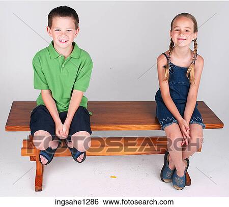 Two children sitting on bench View Large Photo Image Stock Photograph - Two children sitting on bench . Fotosearch
