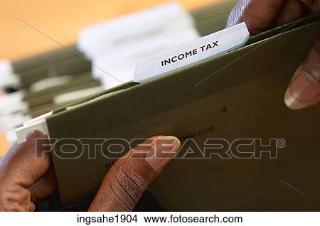 Picture - Woman holding income tax folder BE. Fotosearch