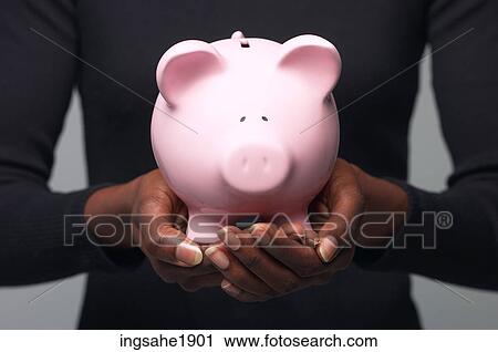 Stock Image - Woman holding piggy bank BE 3. Fotosearch