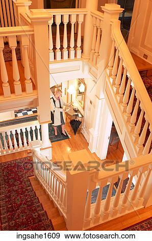 Woman in home at the bottom of staircase View Large Photo Image Stock Photo - Woman in home at the bottom of staircase. Fotosearch