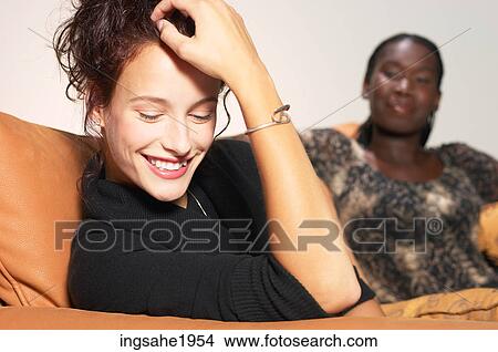 Woman laughing on sofa BE View Large Photo Image Picture - Woman laughing on sofa BE. Fotosearch