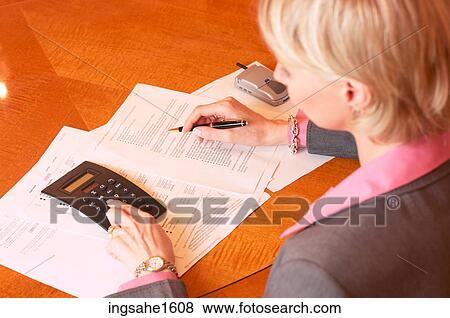 Woman using calculator and holding pencil View Large Photo Image Stock Photo - Woman using calculator and holding pencil. Fotosearch