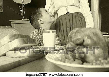 1950s boy with mother at dinner table with chicken View Large Photo Image Stock Photo - 1950s boy with mother at dinner table with chicken . Fotosearch