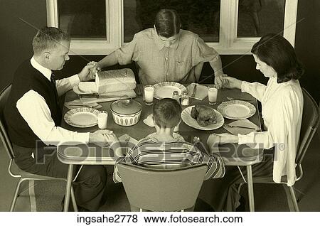 Stock Photo - 1950s family at dinner table praying . Fotosearch