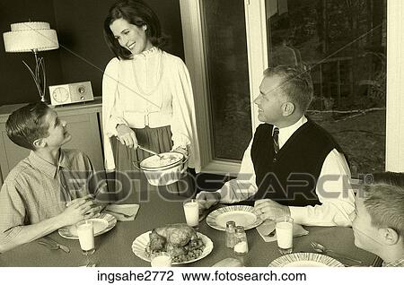 Stock Image - 1950s family at dinner table . Fotosearch