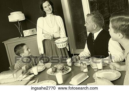 Stock Image - 1950s mature adult couple at dinner table . Fotosearch