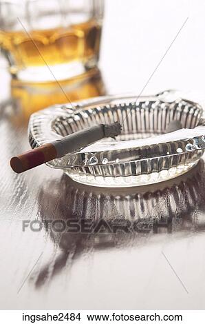 Almost empty mug of beer and cigarette burning in ashtray View Large Photo Image Picture - Almost empty mug of beer and cigarette burning in ashtray. Fotosearch