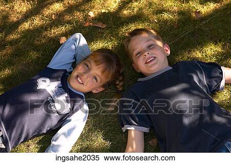 Boy & Girl Lying in grass BE 3 View Large Photo Image Stock Photography - Boy & Girl Lying in grass BE 3. Fotosearch