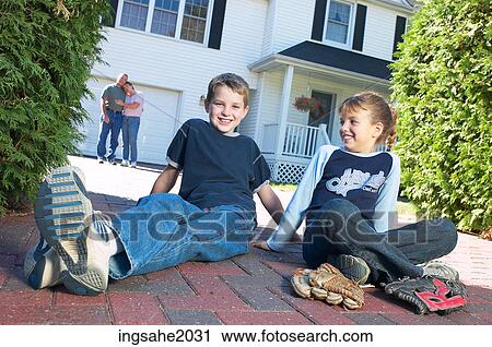 Stock Image - Children sitting in driveway BE 4. Fotosearch