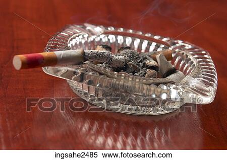 Cigarette burning in ashtray View Large Photo Image Stock Photography - Cigarette burning in ashtray. Fotosearch