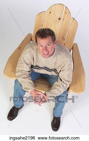 Man in wooden lounge chair View Large Photo Image Stock Photograph - Man in wooden lounge chair . Fotosearch