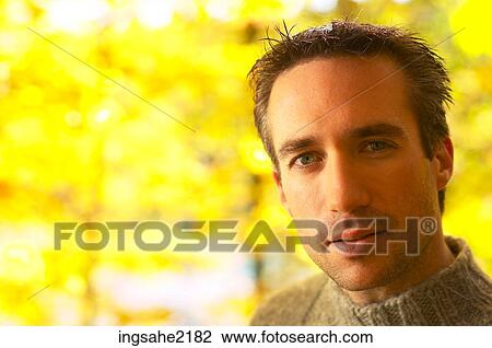 Man with yellow leaves in background View Large Photo Image Stock Image - Man with yellow leaves in background. Fotosearch