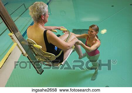 Stock Photo - Patient being lowered into rehabilitation pool an 1. Fotosearch