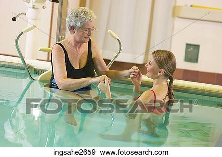 Stock Photo - Patient being lowered into rehabilitation pool an 2. Fotosearch