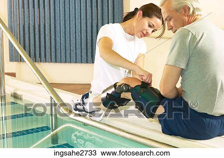 Physical therapist putting knee brace on client View Large Photo Image Stock Image - Physical therapist putting knee brace on client . Fotosearch