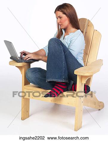 Woman in wooden lounge chair working on laptop View Large Photo Image Stock Image - Woman in wooden lounge chair working on laptop . Fotosearch