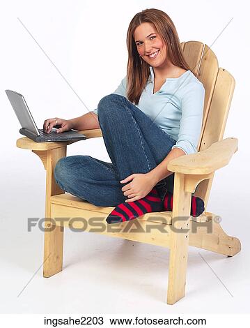 Woman in wooden lounge chair working on laptop View Large Photo Image Stock Image - Woman in wooden lounge chair working on laptop . Fotosearch