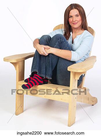 Stock Image - Woman relaxing in wooden lounge chair . Fotosearch