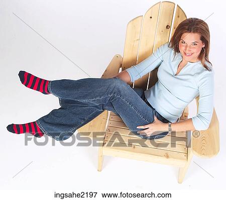 Stock Photo - Woman relaxing in wooden lounge chair . Fotosearch