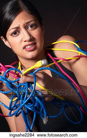 Picture - Woman wrestling with network cables . Fotosearch