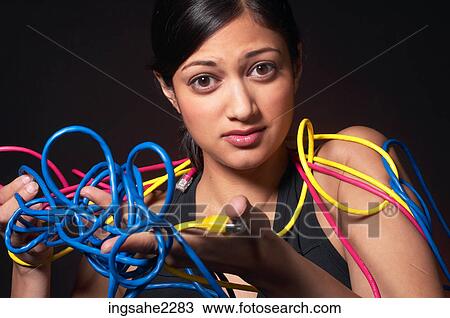 Stock Image - Woman wrestling with network cables . Fotosearch
