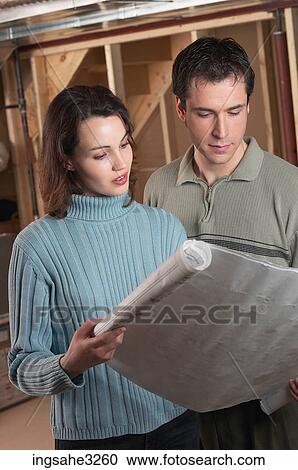 Adult couple looking at blue prints in house under construction View Large Photo Image Stock Image - Adult couple looking at blue prints in house under construction . Fotosearch