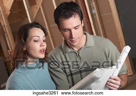 Adult couple looking at blue prints in house under construction View Large Photo Image Stock Image - Adult couple looking at blue prints in house under construction . Fotosearch