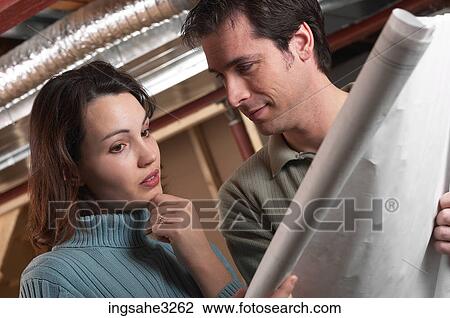 Adult couple looking at blue prints in house under construction View Large Photo Image Stock Image - Adult couple looking at blue prints in house under construction . Fotosearch