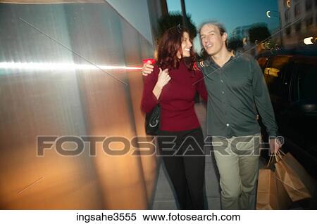 Adult couple walking together with shopping bags View Large Photo Image Stock Photography - Adult couple walking together with shopping bags . Fotosearch