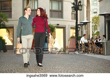 Adult couple walking with shopping bags View Large Photo Image Stock Photo - Adult couple walking with shopping bags . Fotosearch