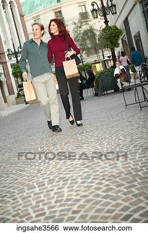 Adult couple walking with shopping bags View Large Photo Image Stock Photograph - Adult couple walking with shopping bags . Fotosearch