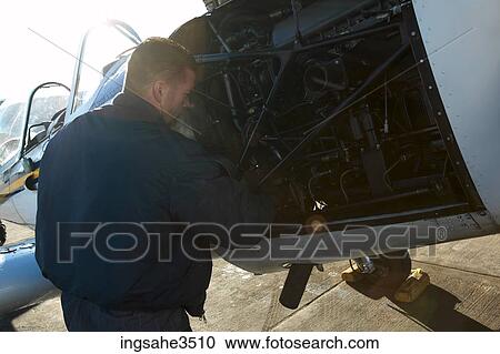 Airplane mechanic fixing engine View Large Photo Image Stock Image - Airplane mechanic fixing engine . Fotosearch