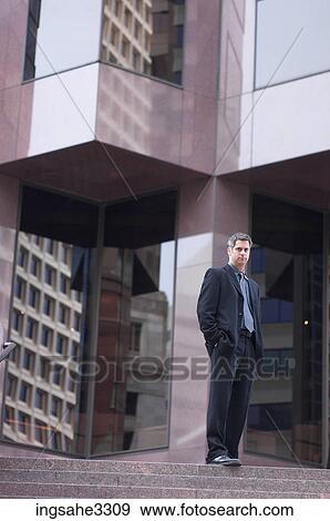 Businessman in front of building View Large Photo Image Stock Photo - Businessman in front of building . Fotosearch