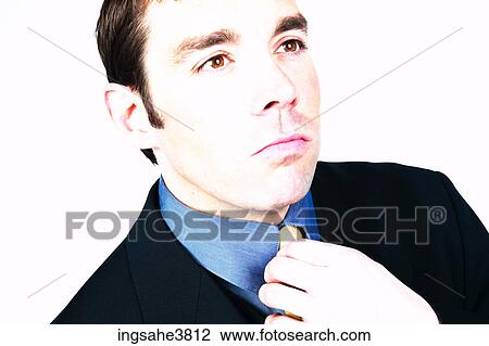 Stock Image - Businessman straightening tie . Fotosearch