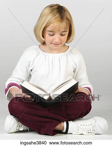 Caucasian blonde girl sitting cross legged and reading from a book View Large Photo Image Stock Image - Caucasian blonde girl sitting cross legged and reading from a book. Fotosearch