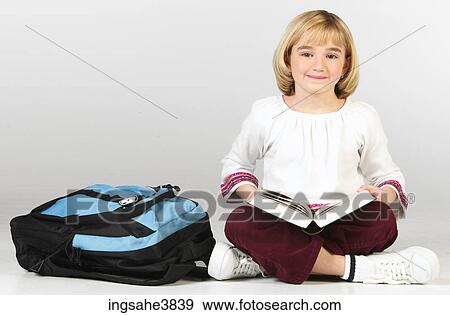 Caucasian blonde girl sitting cross legged with a backpack and a book View Large Photo Image Stock Photo - Caucasian blonde girl sitting cross legged with a backpack and a book. Fotosearch
